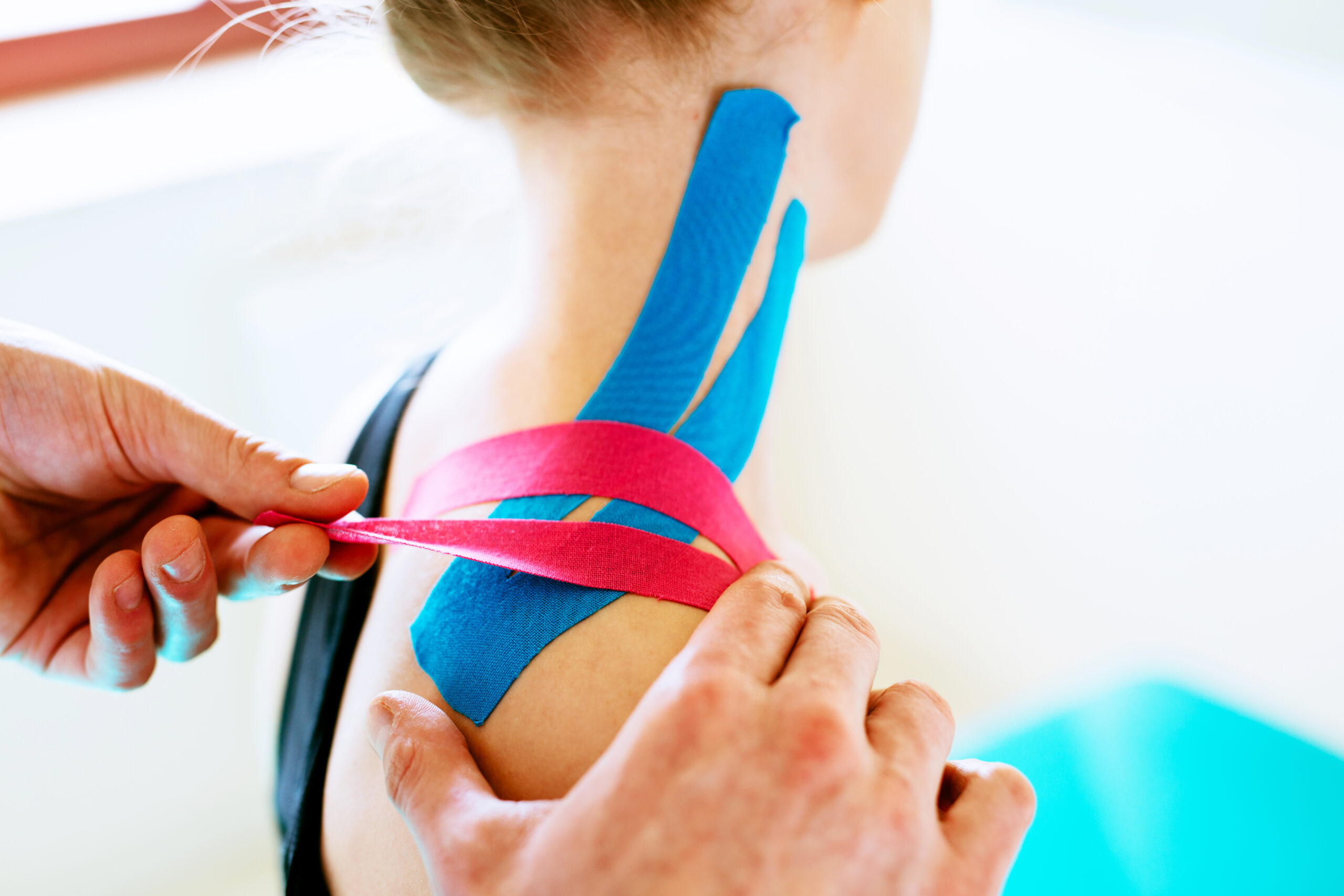 Kinesiotaping. Physical therapist applying tape to patient shoulder
